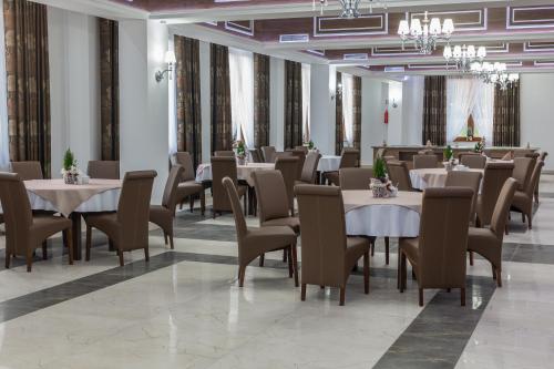 a restaurant with tables and chairs in a room at Borowy Dwór- Biznes, Spa & Fun in Szaflary
