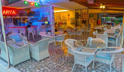 a restaurant with tables and chairs and a bar at Arya Otel in Marmaris
