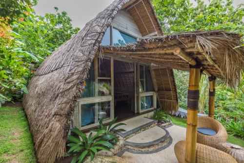 a small house with a straw roof at Milo's Home in Jimbaran