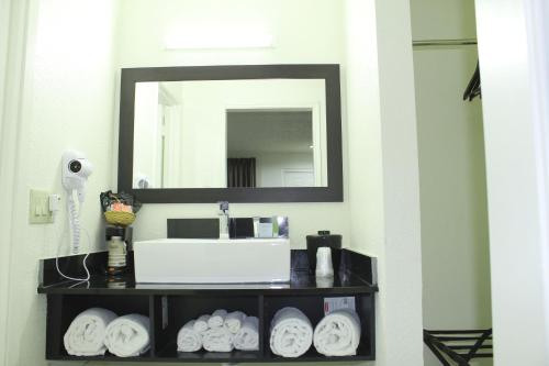 a bathroom shelf with a mirror and a hair dryer at Stay Express Inn Dallas - Fair Park / Downtown in Dallas