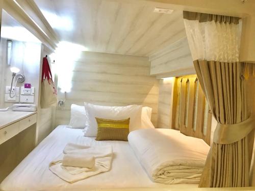 een slaapkamer met een groot wit bed in een kamer bij Mariya Lady Hostel At Suvarnabhumi Airport in Lat Krabang