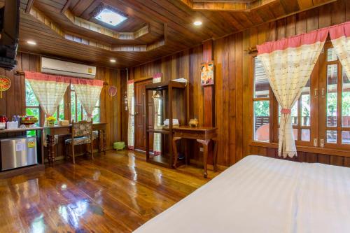 a bedroom with wooden walls and a bed in a room at Suksatan Lamphun in Lamphun