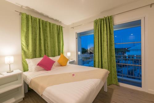 洛坤的住宿－查達@洛酒店，一间卧室设有一张床和一个大窗户