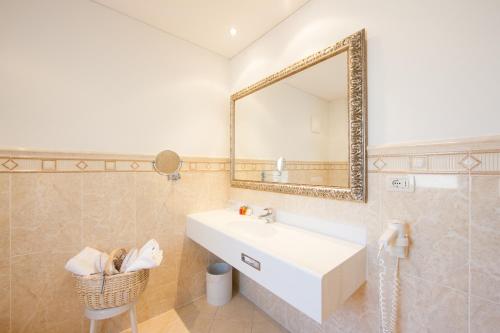 a bathroom with a sink and a mirror at Hotel MARIA THERESIA adults-only in Lagundo