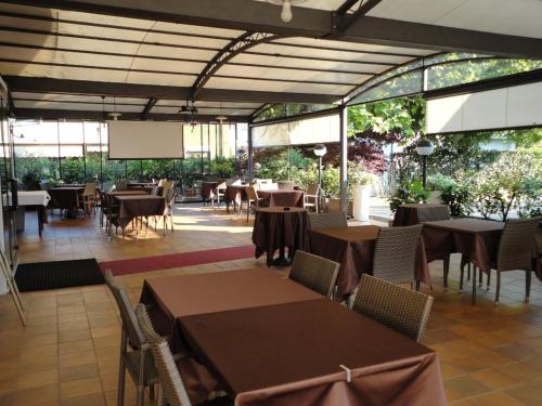 a restaurant with tables and chairs and windows at San Marco in Montecchio Maggiore