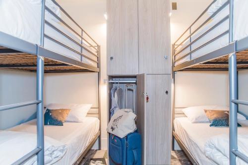 a room with two bunk beds and a suitcase at Tainan Gu Hostel in Tainan