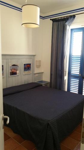 ファヴィニャーナにあるCala la Lunaのベッドルーム1室(大きな黒いベッド1台、窓付)