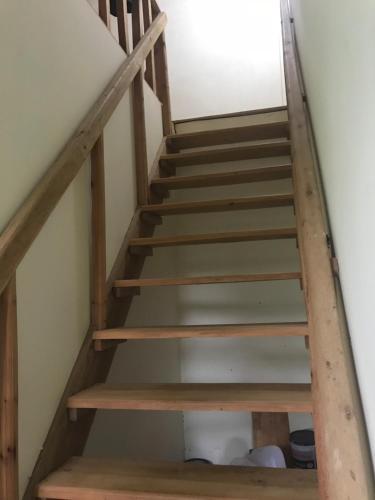 a set of wooden stairs in a house at Bao Loc Homestay in Bao Loc