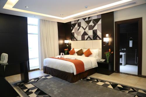 a bedroom with a large bed and a bathroom at Bayat Suites in Muhayil