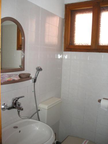 a bathroom with a toilet and a sink and a mirror at Guest House Bolyarka in Koprivshtitsa