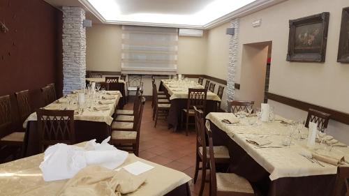 un comedor con mesas y sillas con mantel blanco en La Taverna en Morcone