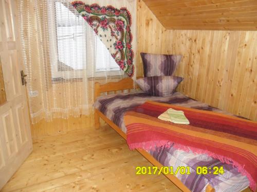 ボロフタにあるLisovychokのベッドと窓が備わる小さな客室です。