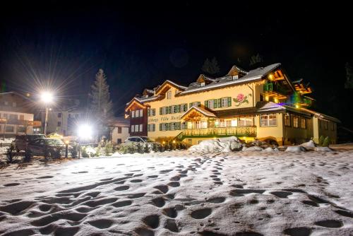 a snow covered street in front of a building at Hotel Villa Rosella Park & Wellness in Canazei