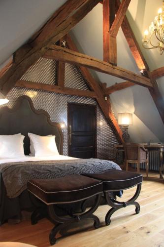 a bedroom with a bed with a bench in it at L'Hibernie in Rochefort-en-Yvelines