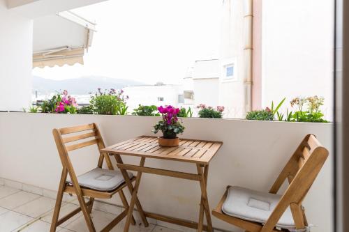 - Balcón con mesa pequeña y 2 sillas en Holargos Metro Rooms, en Atenas