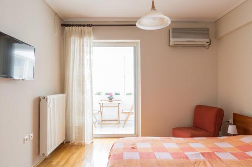um quarto com uma cama, uma cadeira e uma janela em Holargos Metro Rooms em Atenas