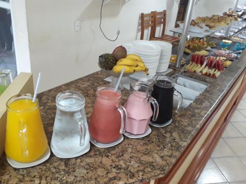 a bunch of different colored drinks on a kitchen counter at Hotel Pousada Ilha do Mar Bombinhas in Bombinhas