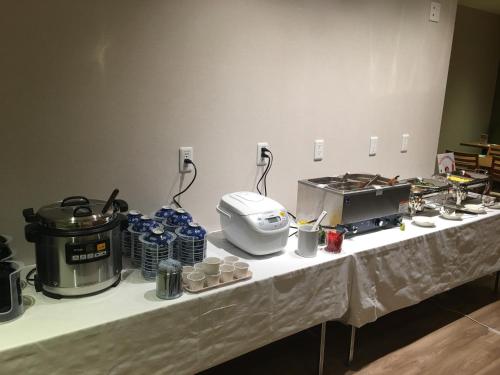 une table avec un comptoir où se trouvent de la nourriture et une casserole dans l'établissement Hotel Crown Hills Onahama, à Iwaki