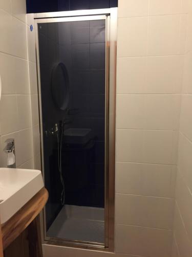 a shower with a glass door next to a sink at Les Cristaux in Saint-Gervais-les-Bains