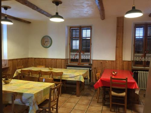 un restaurant avec des tables et des chaises et une horloge sur le mur dans l'établissement Les Cristaux, à Saint-Gervais-les-Bains