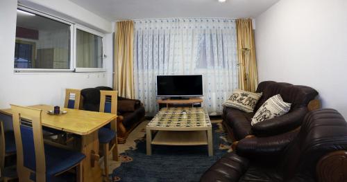 sala de estar con sofá y TV en Alpenresorts Landeck, en Landeck