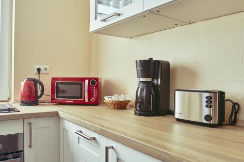 a kitchen with a microwave and a coffee maker on a counter at Hotel Restaurant Doppeladler in Rees