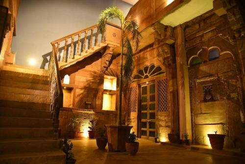 a building with a staircase and a palm tree at Rani Mahal in Jodhpur