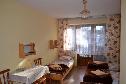 ビャウカにあるU Dziadkowcówのベッド2台、テーブル、窓が備わる客室です。