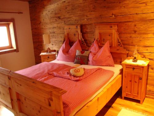 ein Schlafzimmer mit einem großen Bett in einem Blockhaus in der Unterkunft Alpenbauernhaus Vorderbrandthof in Saalbach-Hinterglemm