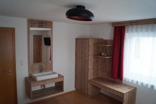 ein Bad mit einem Waschbecken und einem Spiegel in der Unterkunft Flierelerhof in Arzl im Pitztal