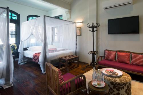 a living room with a bed and a couch at Noordin Mews in George Town