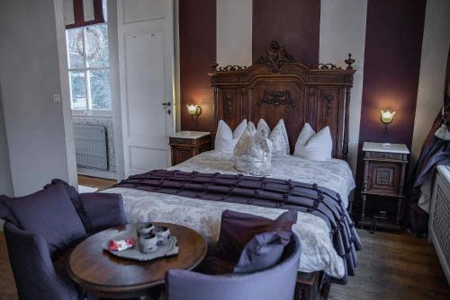 マルメディにあるDépendance Maison Géronのベッド、テーブル、椅子が備わるホテルルームです。
