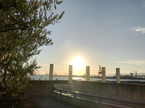 a sun setting over the water with a bridge at Hotel Seagull Tenpozan Osaka in Osaka