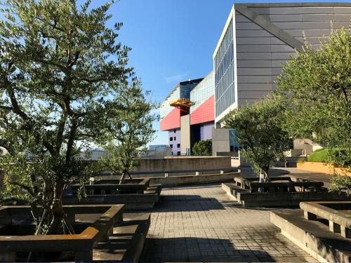 a courtyard with benches and trees in front of a building at Hotel Seagull Tenpozan Osaka in Osaka