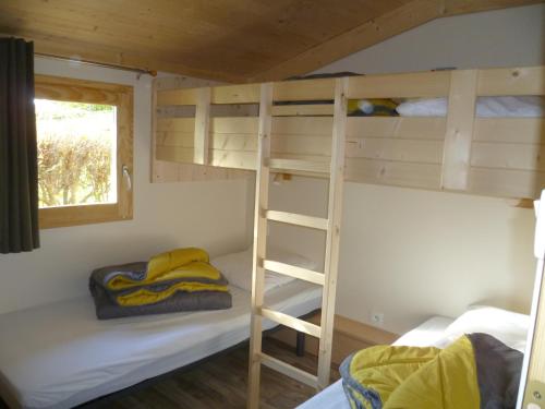 two bunk beds in a tiny house with a ladder at Camping Pré-Fixe in Cassagnabère-Tournas