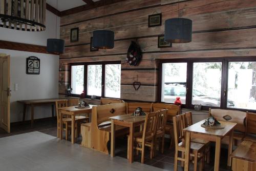 a restaurant with wooden walls and tables and chairs at Haus Izabella in Filzmoos