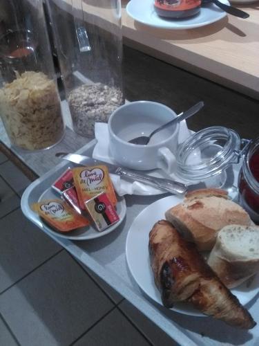 a plate of food with bread and a cup of coffee at Logis Hotel L'ange Couronne in Belleville-sur-Saône