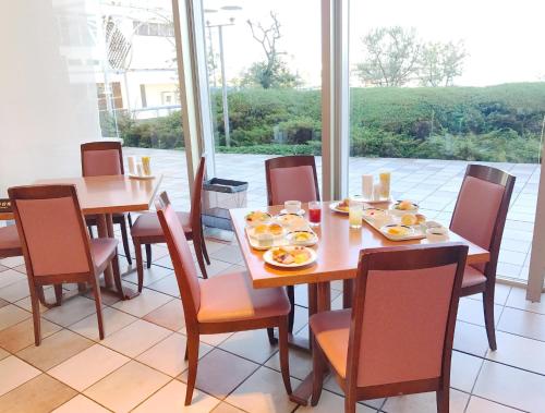 a dining room with a table and chairs with food on it at Hotel Seagull Tenpozan Osaka in Osaka