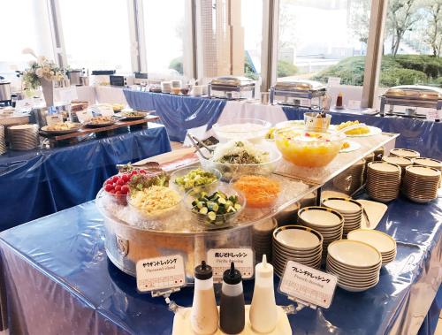 a buffet of food on a table with bowls and plates at Hotel Seagull Tenpozan Osaka in Osaka