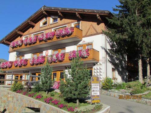 a building with flower boxes on the side of it at Hotel Duc De Rohan in Livigno