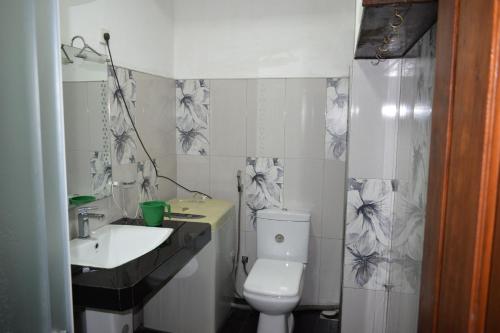 a bathroom with a white toilet and a sink at Cecilia Cottage in Nuwara Eliya