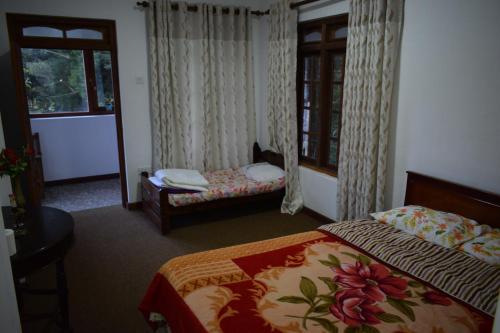 a hotel room with two beds and a window at Cecilia Cottage in Nuwara Eliya