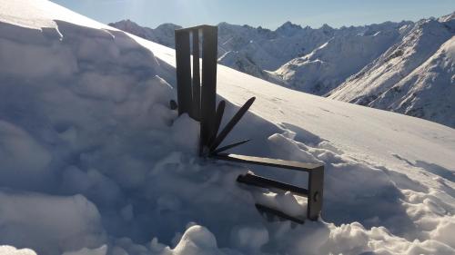a snow covered mountain with a clock in the snow at Apart Lechtraum in Stanzach
