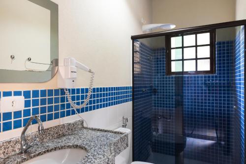 uma casa de banho com um chuveiro, um lavatório e um WC. em Pousada Ilhote da Prainha em Ilhabela