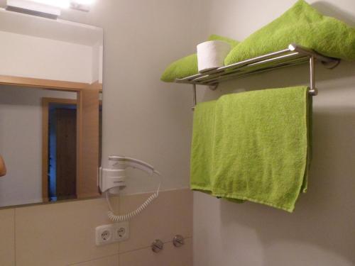 a bathroom with a green towel and a mirror at Berggasthaus Kraxenberger in Brannenburg