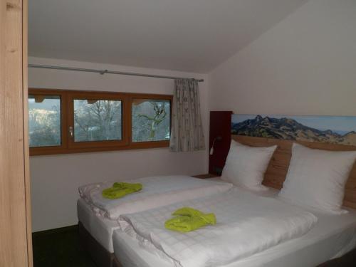 a bedroom with two beds with green towels on them at Berggasthaus Kraxenberger in Brannenburg
