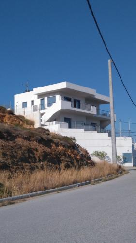 ein weißes Gebäude an der Seite eines Hügels in der Unterkunft Dimitris House in Karystos