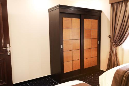a bedroom with a closet with wooden doors at Sakan com Jeddah in Jeddah