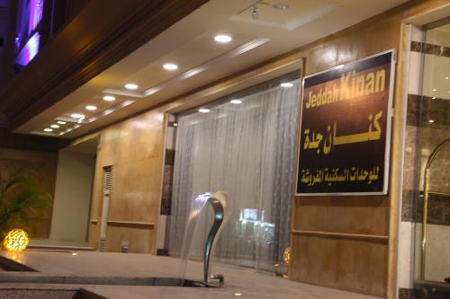 a hotel lobby with a large glass door with a sculpture at Sakan com Jeddah in Jeddah