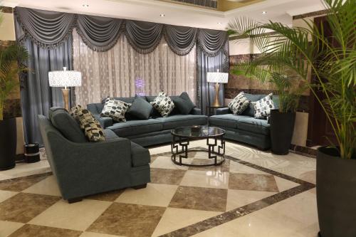 a living room with couches and a table and plants at Sakan com Jeddah in Jeddah
